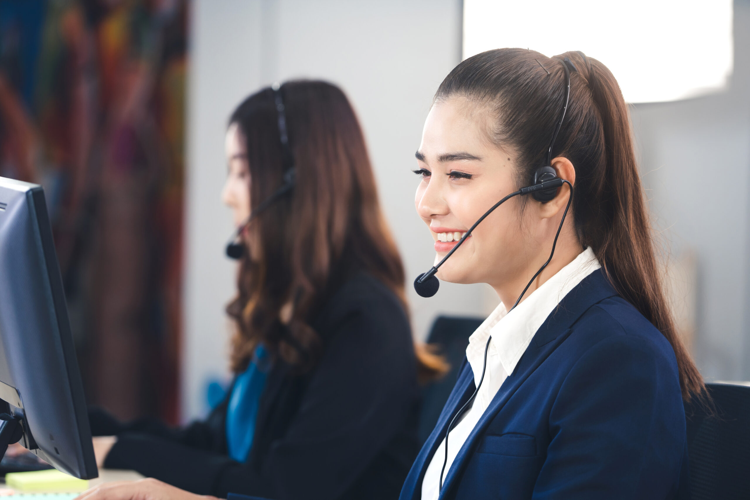 Women providing customer support at call center on a headset